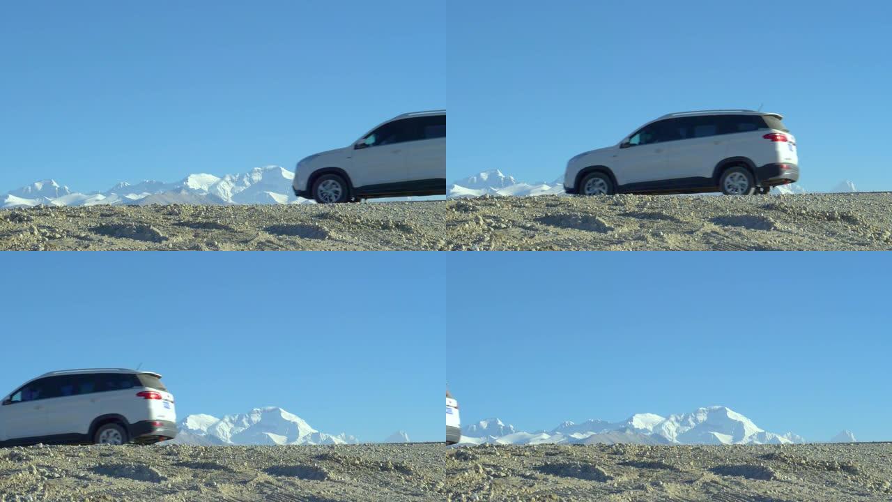 慢动作: SUV沿着砾石路径行驶，可以看到冰川。