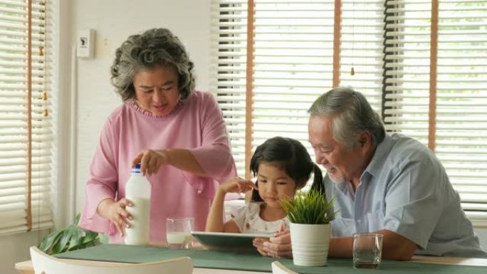 快乐的祖父和祖母与小孙女一起在家放松情绪。人们有放松、老年、退休、老年生活方式的家庭观念。