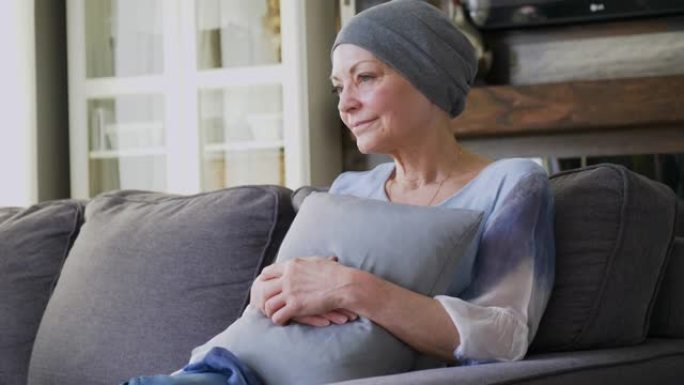 一位患有癌症的老年妇女坐在沙发上。