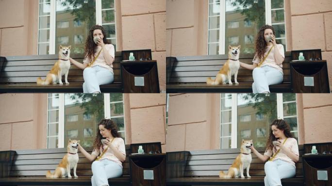 快乐的年轻女子在咖啡馆户外喝茶，抚摸可爱的柴犬小狗