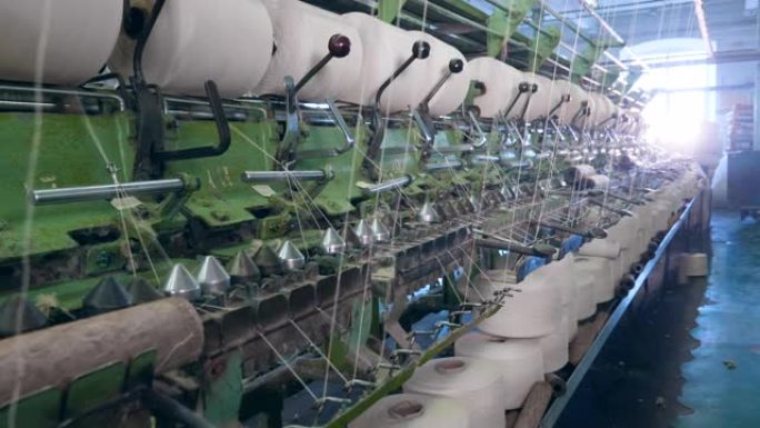 线轴缠绕白线的缝纫机。现代纺织厂。