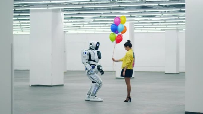 微笑的女人把许多气球送给一个站在房间里的机器人。