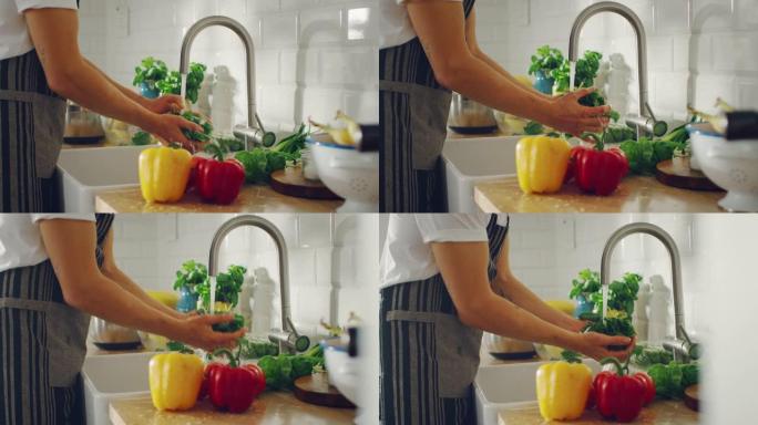 慢动作特写镜头，一个男人用自来水洗绿色菠菜叶。正宗的时尚厨房配健康蔬菜。有机农业手工清洗的天然清洁产
