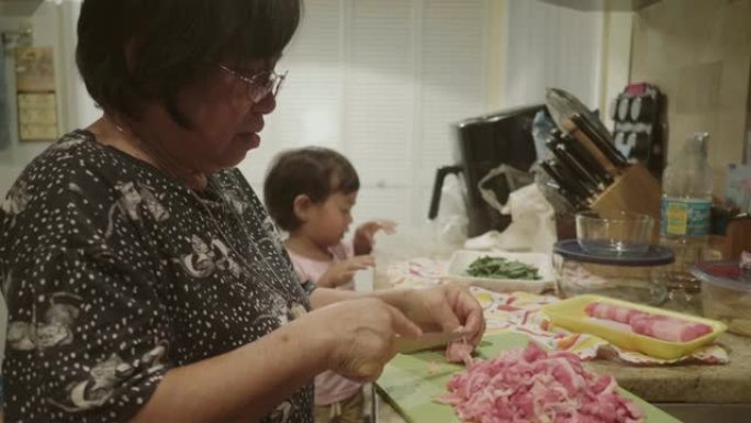 亚洲男婴和他的祖母一起做饭。