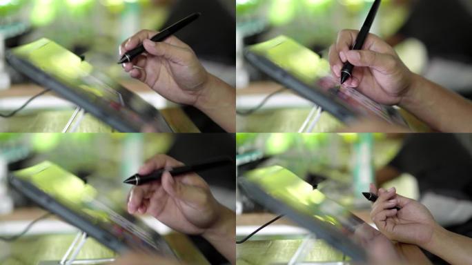 亚洲男子专业设计师使用绿色自然光的图形平板电脑在创意办公室工作