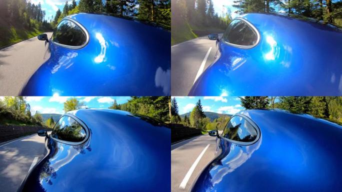 蓝色跑车在空旷的蜿蜒乡间小路上行驶，被阳光照亮