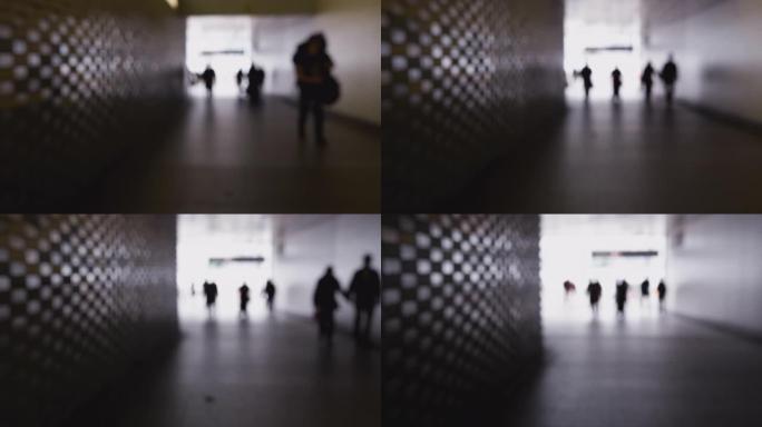 匿名人士穿过城市地下通道的散焦镜头