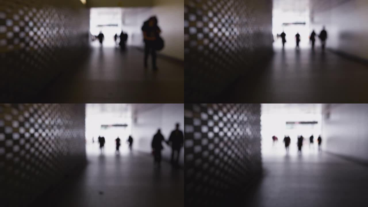 匿名人士穿过城市地下通道的散焦镜头