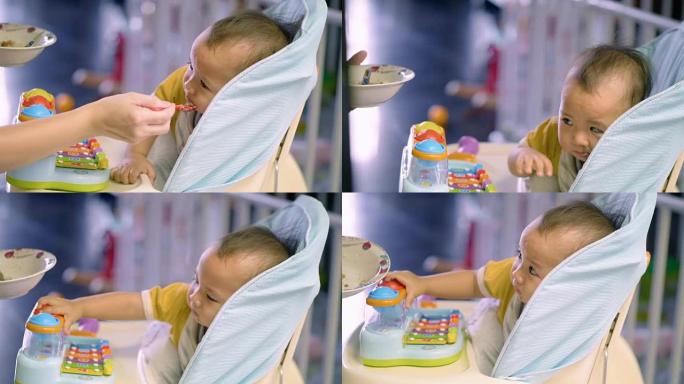 男婴在椅子上玩耍和吃饭