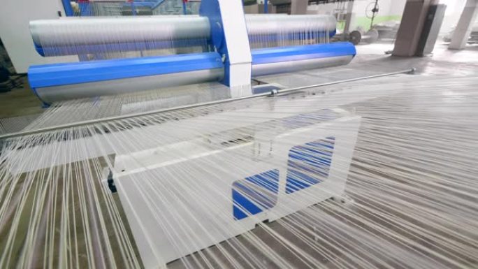 在现代工厂机器上编织织物的过程。