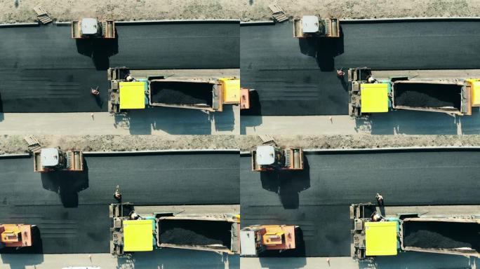 工人们正在做一条沥青高速公路。道路施工现场的沥青摊铺机。