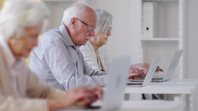 老年人在计算机课上使用笔记本电脑