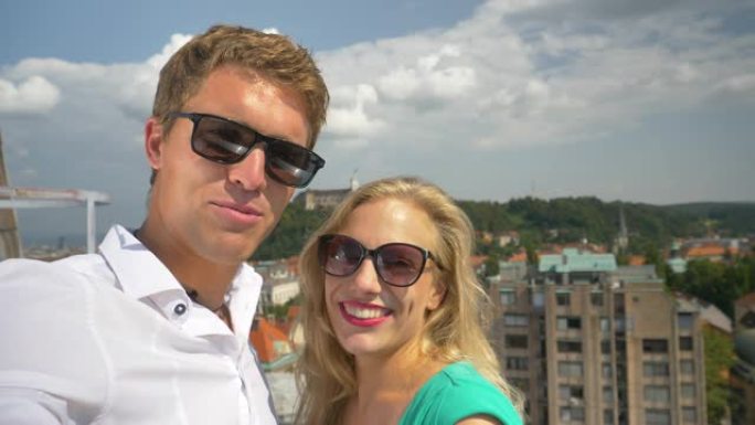 自拍照: 开朗的夫妇在阳光明媚的斯洛文尼亚的屋顶上拍摄了一个新的vlog帖子。