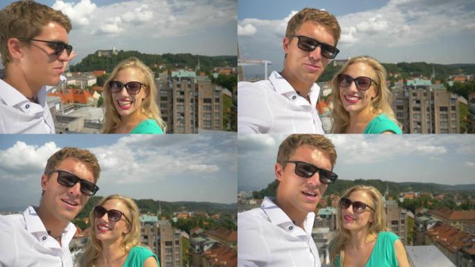 自拍照: 开朗的夫妇在阳光明媚的斯洛文尼亚的屋顶上拍摄了一个新的vlog帖子。