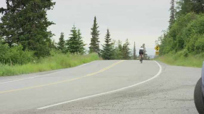 骑自行车的人沿着乡村公路骑行