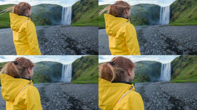 女性游客欣赏冰岛最大，最美丽的瀑布之一Skogafoss