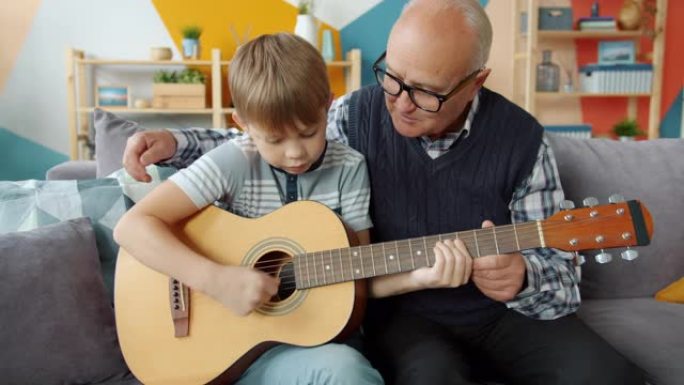 老人教才华横溢的小孙子在公寓里弹吉他