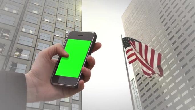 在美国迈阿密的金融迈阿密中心和美国国旗下，男性手持旧的Smarphone绿色屏幕。