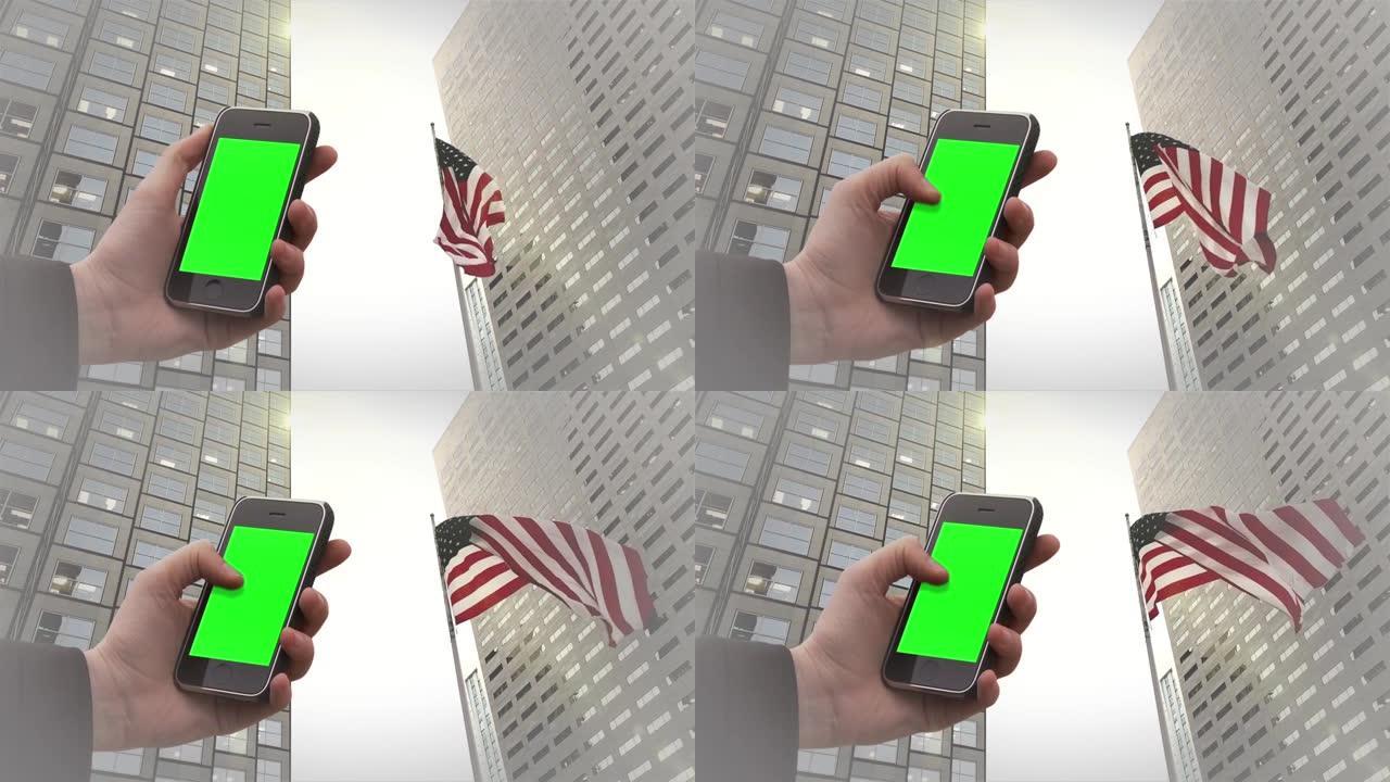 在美国迈阿密的金融迈阿密中心和美国国旗下，男性手持旧的Smarphone绿色屏幕。