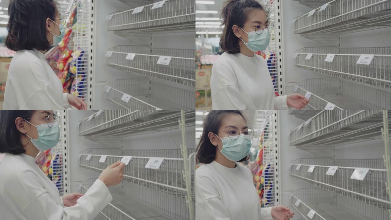 年轻女子在泰国曼谷的一家杂货店看着空荡荡的货架。