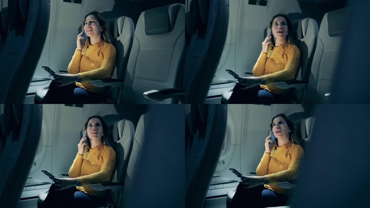 一个女人坐在飞机机舱里打电话