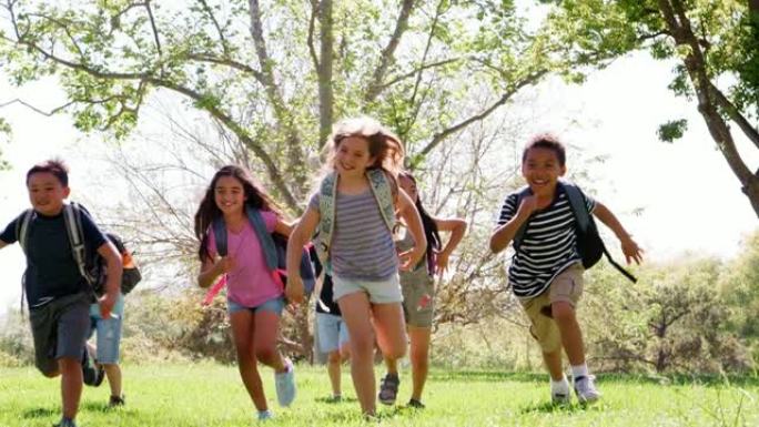一群在公园里有朋友的孩子朝着慢动作拍摄的相机奔跑