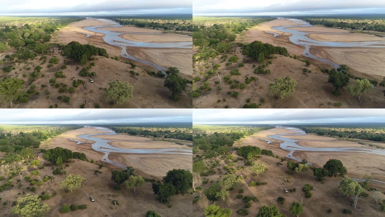 津巴布韦戈纳雷周国家公园一辆4x4野生动物园车辆沿着河边行驶的鸟瞰图