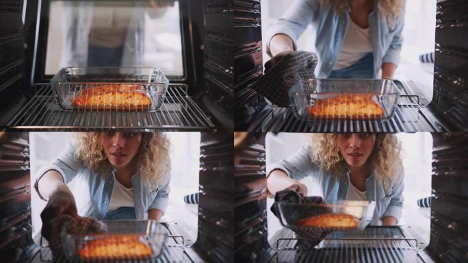 当女人烹饪烤箱烤鲑鱼时，从烤箱内看
