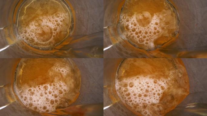 倒入啤酒杯的生啤酒。自上而下的视图。玻璃内飞溅的冷啤酒
