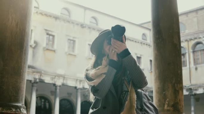 快乐的职业女记者用相机在威尼斯老城古建筑用古董柱子拍照