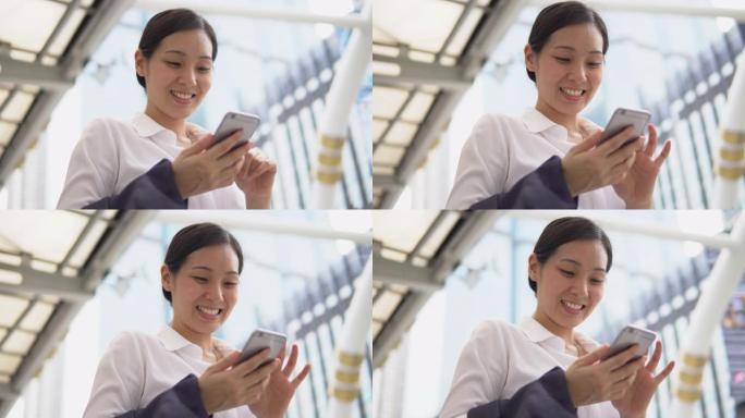 亚洲商业女性通过电话发短信