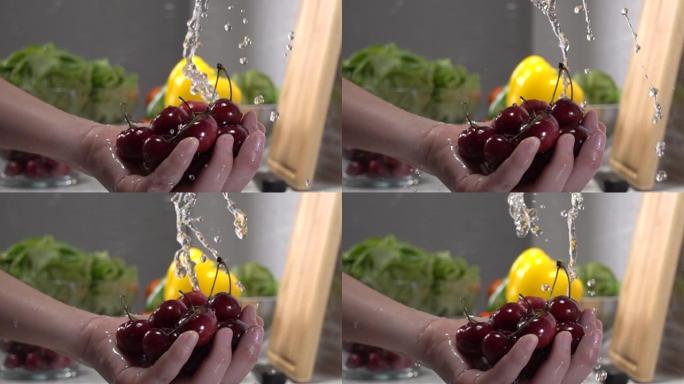 超级慢动作女人在流水下洗手新鲜樱桃。冲洗成熟的红樱桃