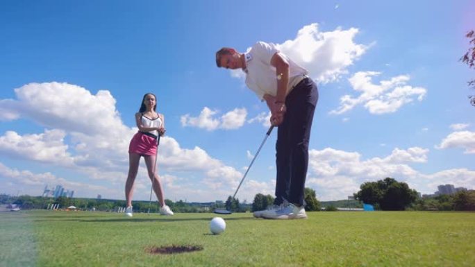 一位女士和一位男士兴高采烈地打高尔夫球