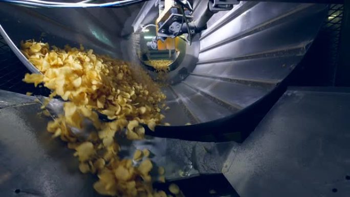 许多油炸薯条在工厂机器中分类，与增味剂混合。