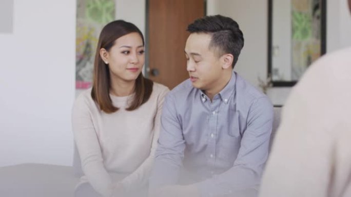 年轻的亚洲夫妇与治疗师交谈