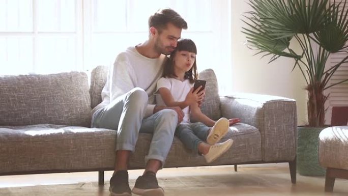 快乐的父亲和小女儿自拍看智能手机