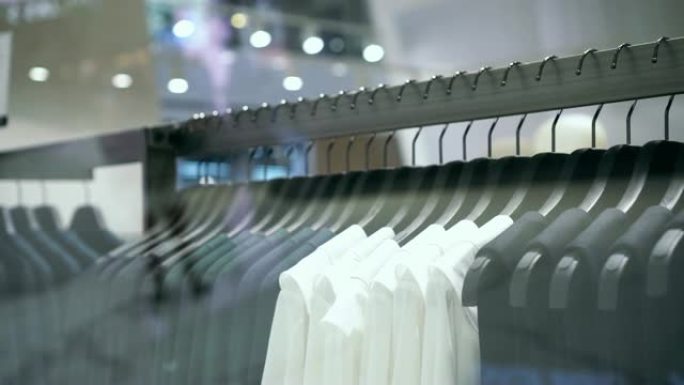 4k镜头在百货商店，购物中心和服装概念的时尚服装店的衣架上悬挂衣架和栏杆的销售展示