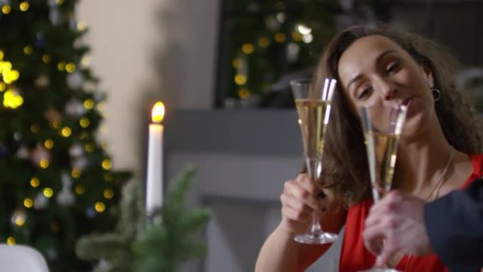 白人妇女在圣诞节派对上与男人碰碰香槟酒杯