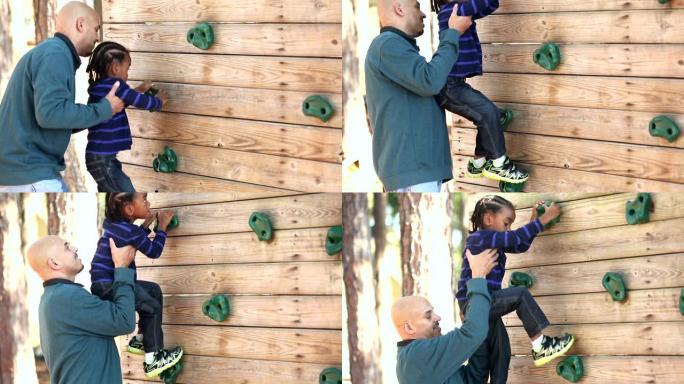 父亲帮助小男孩爬墙