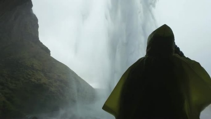 站在冰岛Skogafoss瀑布后面的雨中女士