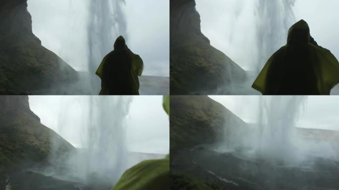 站在冰岛Skogafoss瀑布后面的雨中女士