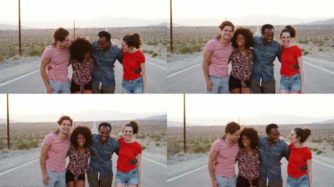 四个快乐的朋友站在沙漠高速公路上，特写