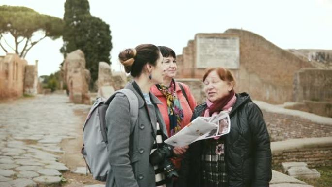 年轻的高加索女性游览导游向两名高级女性游客详细介绍了意大利奥斯蒂亚的历史遗迹