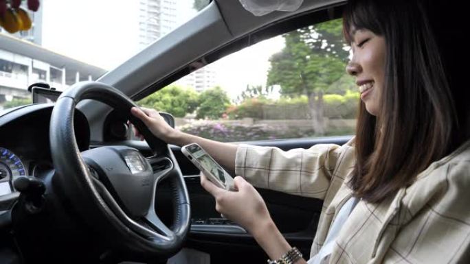 亚洲女性在城市使用智能手机和驾驶汽车