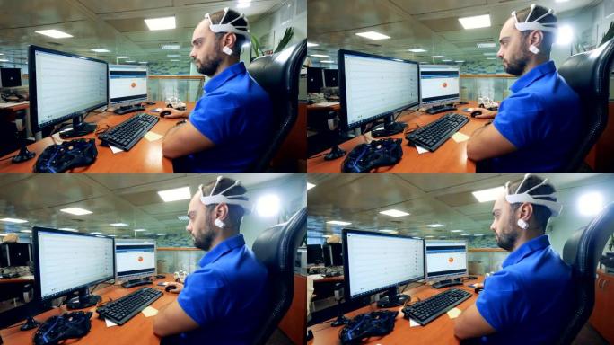 男性工程师使用特殊的脑波扫描耳机控制计算机
