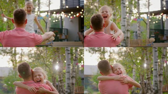 可爱的小女孩跑向父亲，他站在膝盖上拥抱她。在阳光明媚的夏日里，在花园里玩耍，家庭幸福的时刻。