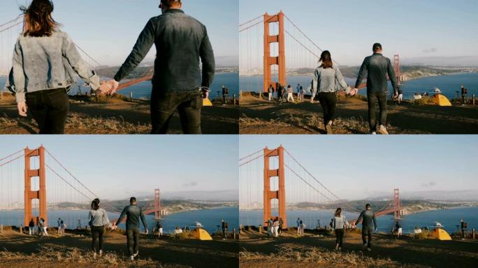 背景式快乐的男人和女人在旧金山金门大桥的史诗般的美丽景色中携手同行。