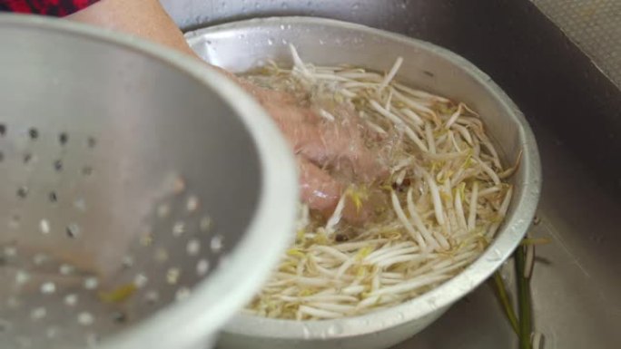 亚洲妇女在厨房洗手和清洁新鲜的豆芽