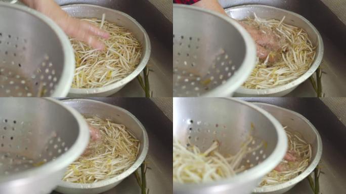 亚洲妇女在厨房洗手和清洁新鲜的豆芽