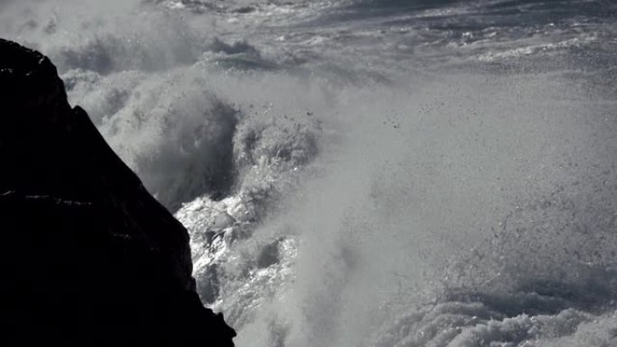 海浪压碎熔岩海岸。慢动作镜头。